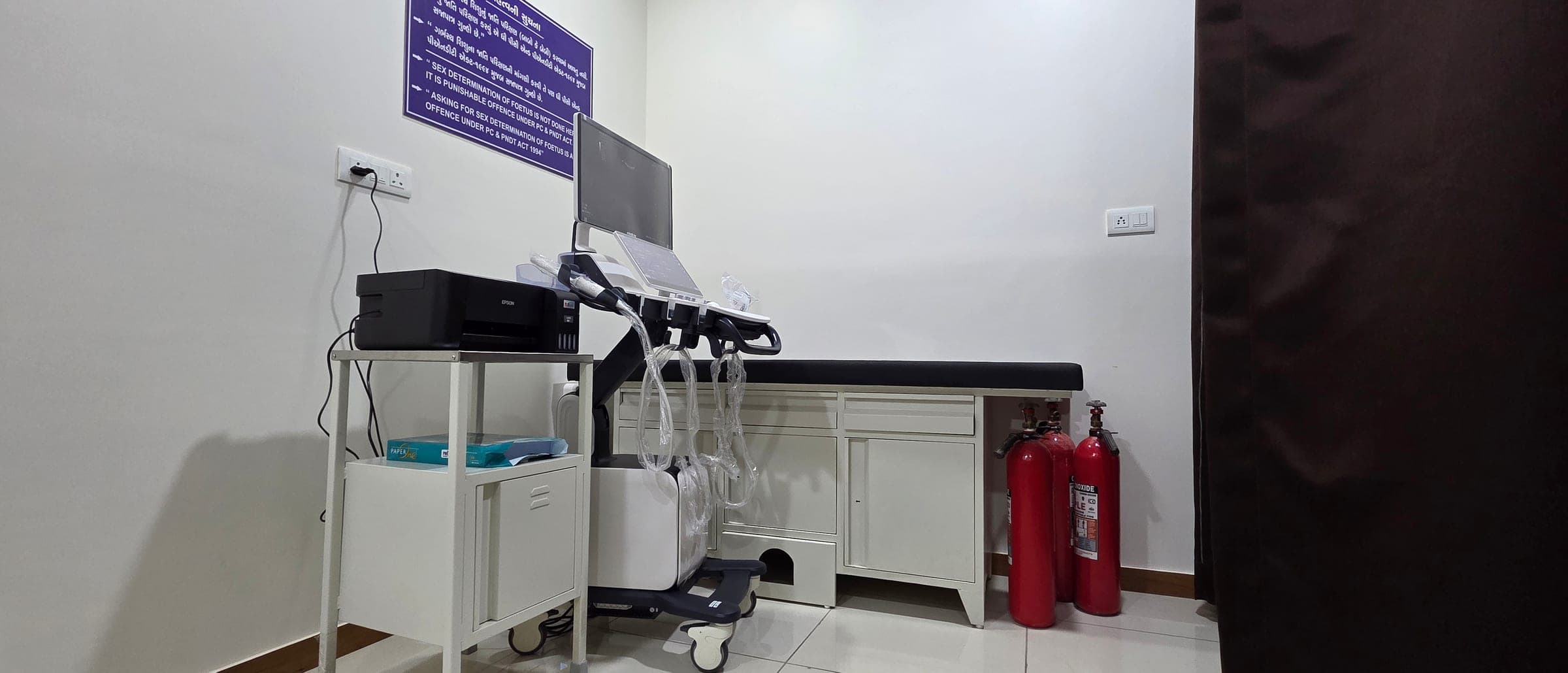 Sonography room with ultrasound machine and examination couch at Krisha Women's Hospital